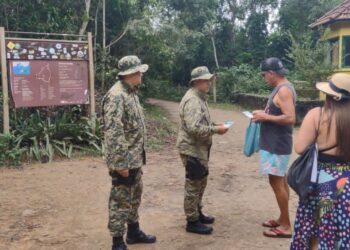 Polícia ambiental distribui panfletos com o telefone do Linha Verde da Ilha Grande