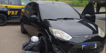 Policiais da PRF ao lado de veículo abordado na BR-393 em Dorândia com 13,7 kg de cocaína apreendidos nesta terça-feira (19)